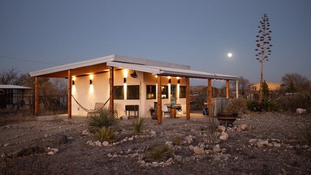 A modern house with a covered patio, a hammock, and a fire pit. - Sunset Ranch, a private acre lot facing open ranch land and high planes desert (Marathon)