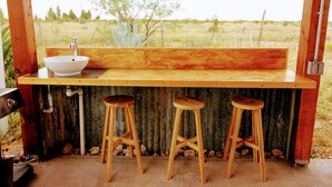 A rustic wooden bar with a white sink and three wooden stools. - Sunset Ranch, a private acre lot facing open ranch land and high planes desert (Marathon)