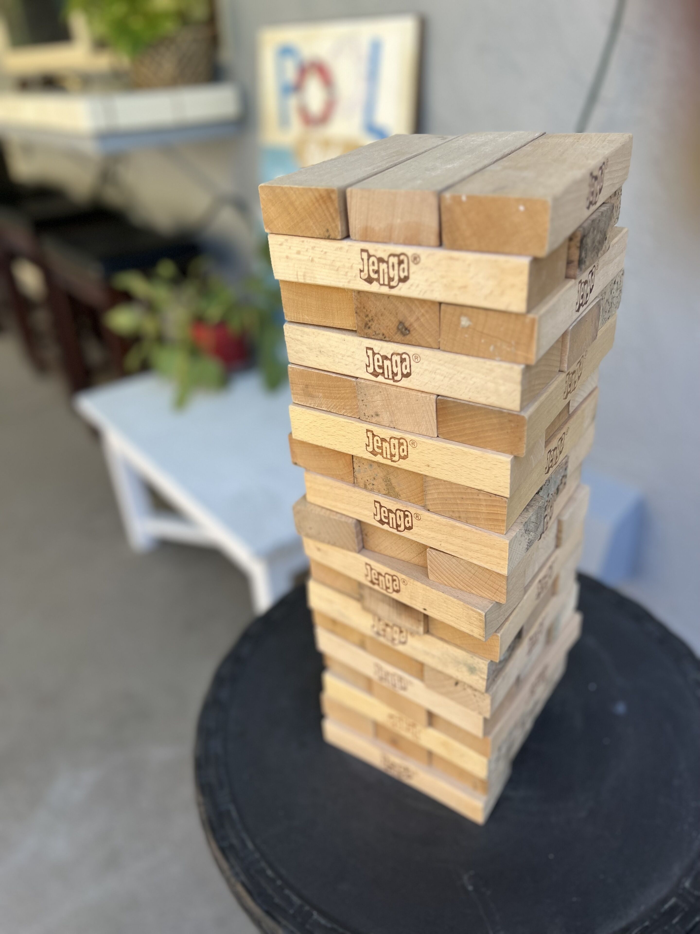 Ein Stapel Holzklötze mit dem Aufdruck 'Jenga' auf einer schwarzen Oberfläche.