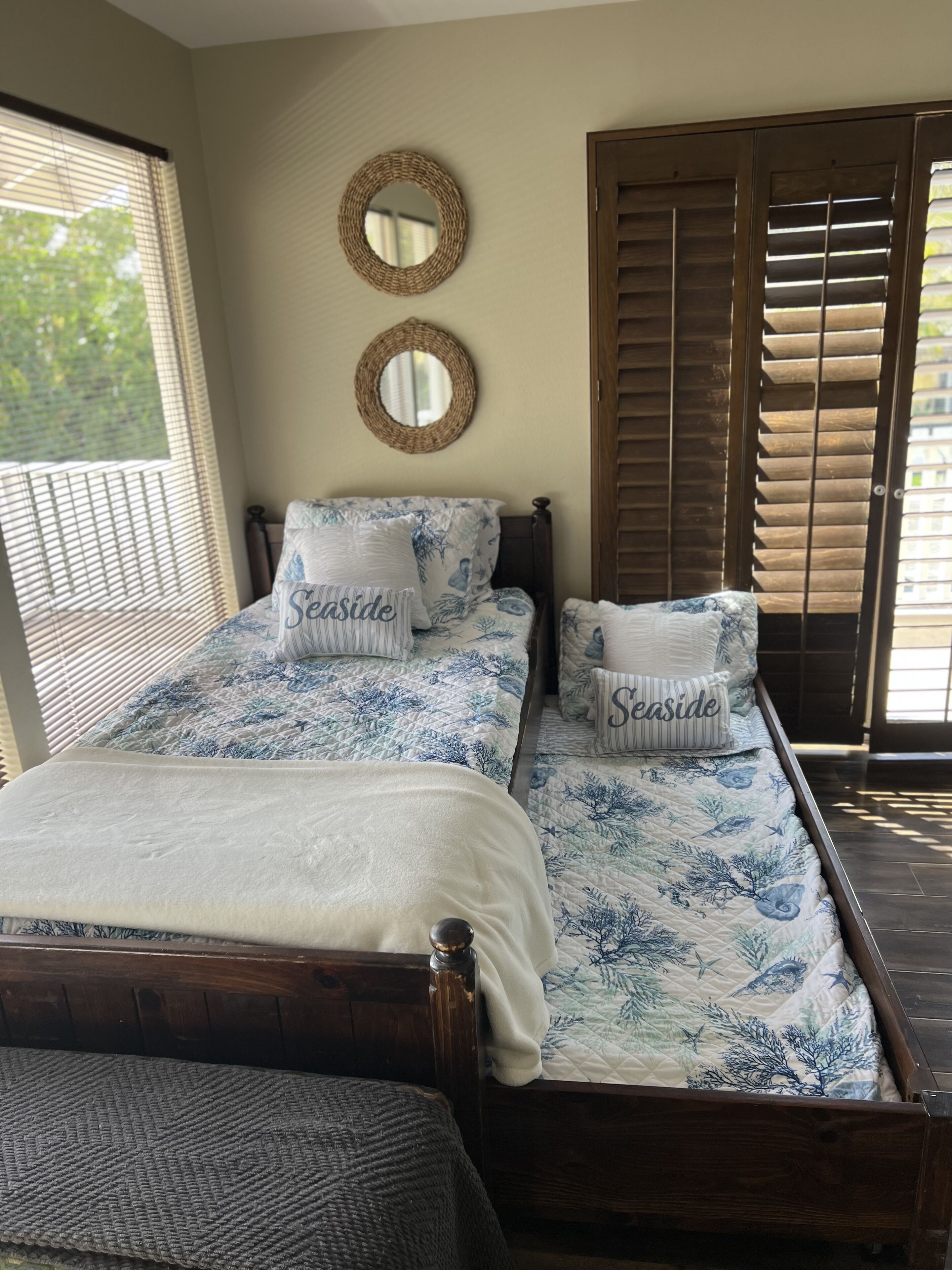 A double bed with a floral bedspread and two pillows labeled "Seaside."