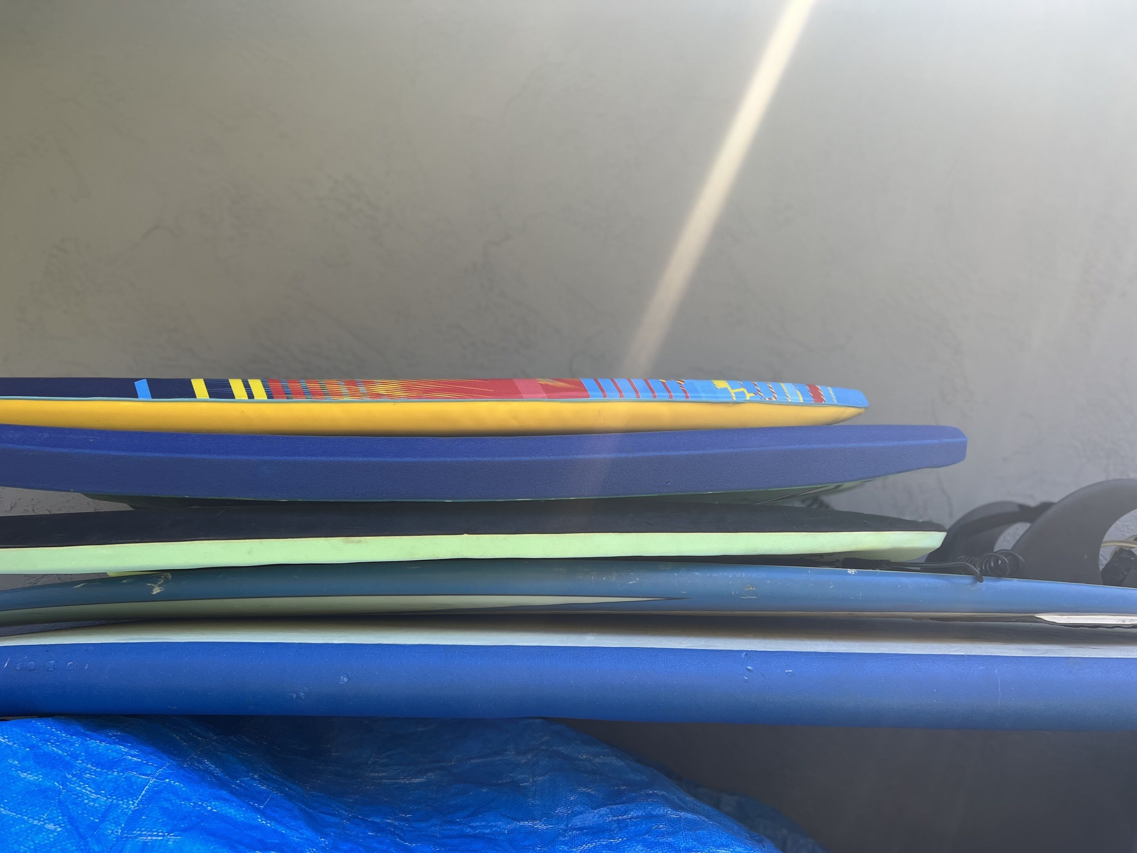 Una pila de esterillas con varios colores y diseños, incluyendo azul, amarillo y rojo.
