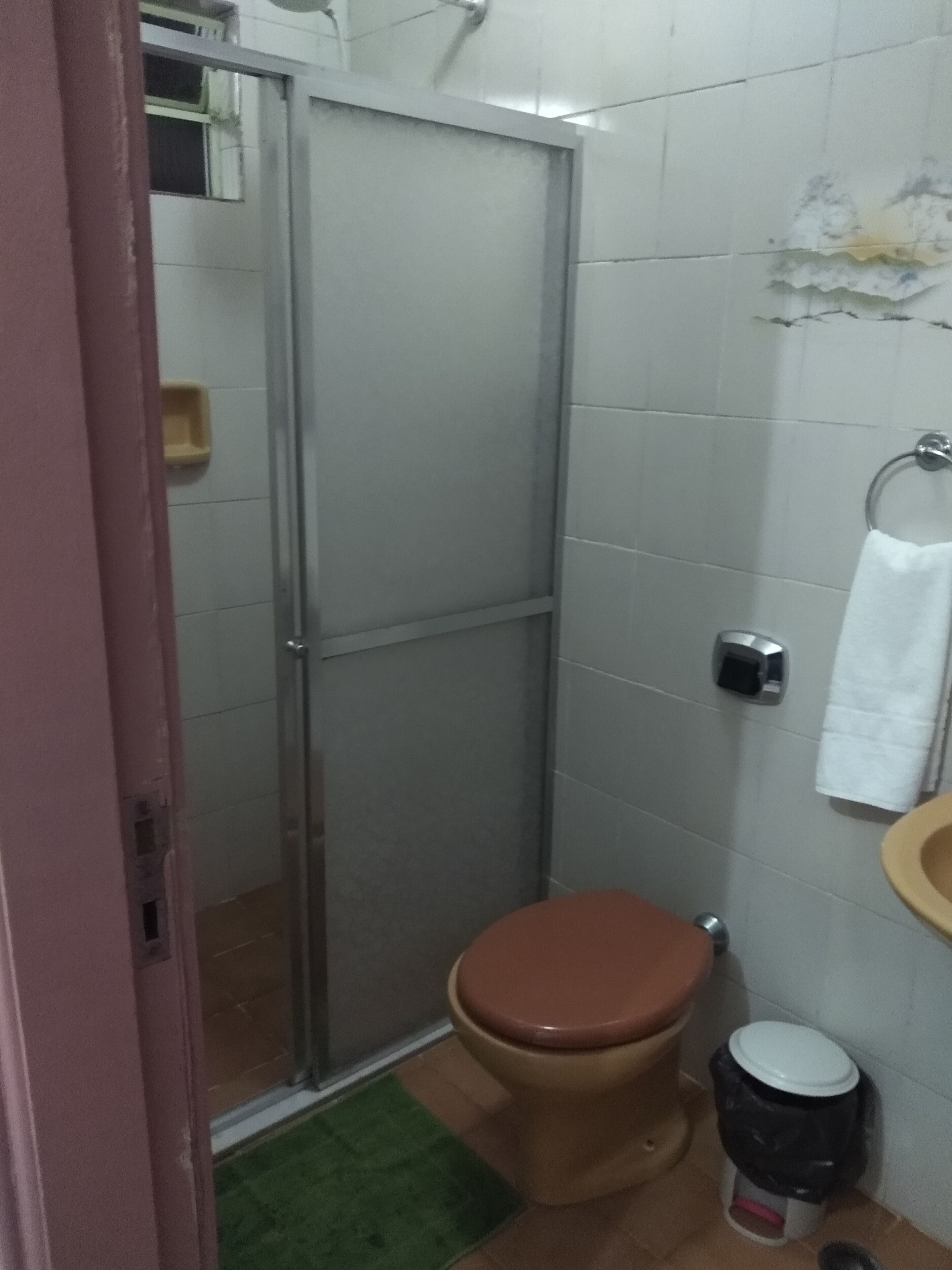 A bathroom with a toilet, bidet, and a glass-enclosed shower stall.