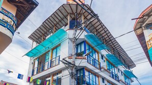 A multi-story hotel with balconies, a sign reading "Hotel Guatatur," and a cobblestone street. - Hotel Guatatur (Guatapé)