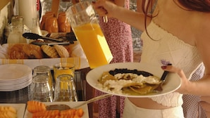 Un montaje tipo bufé con diversas opciones de comida y un dispensador de bebidas.