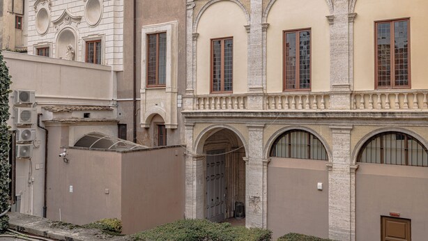 A building with classical architecture, featuring arched windows and a central doorway.