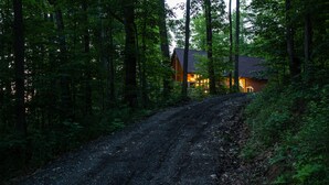 A cabin in a forest with a dirt path leading to it. - Pine Lane is your cozy, pet-friendly escape -w/ hot tub, fire pit, & peaceful vibes near Mohican (Butler)