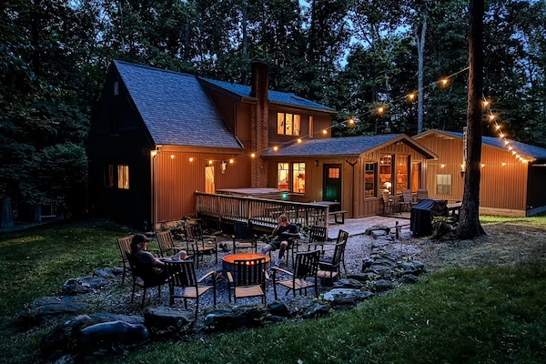 Unwind beneath the string lights in your own secluded backyard—complete with a hot tub, fire pit, and nothing but forest around you.