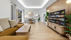 Un salon moderne avec un canapé, une table basse, un téléviseur et des éléments décoratifs en bois.
