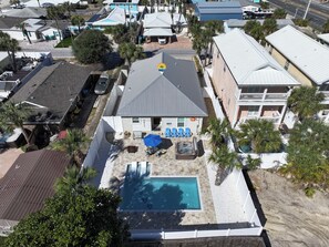 A residential area with a swimming pool, patio furniture, and a covered outdoor seating area.