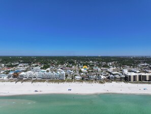 A coastal town with beachfront properties, clear skies, and a view of the ocean.