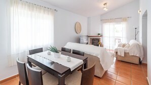 Un salon moderne comprenant un coin repas, une cheminée et un canapé.