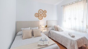 Une chambre d’hôtel avec deux lits, une table de chevet avec une lampe et un élément décoratif mural.