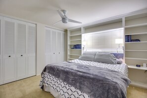 A bedroom with a bed, a ceiling fan, built-in shelving with books, and a window with blinds. - Tucson Townhome w/ Shared Pool in 55 + Community! (Tucson)
