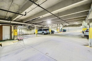 A multi-level parking garage with concrete floors and pillars, featuring several parked vehicles and a metal cart. - Charlie's Slopeside: Bear Paw, Ski-In/Out, Sleeps 8, Bachelor Gulch + Ritz Pool & Hot Tub Access (Beaver Creek)