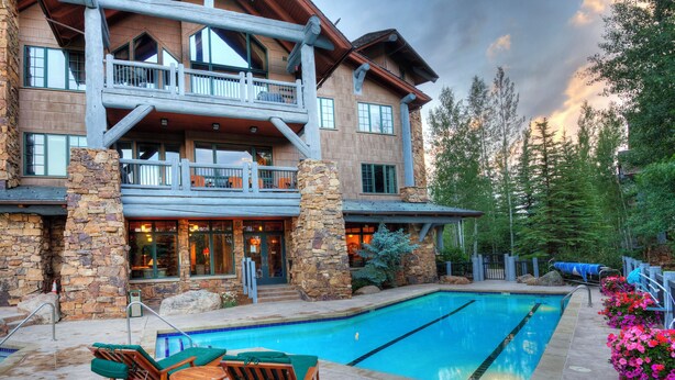 A two-story lodge with a stone facade, a pool, and outdoor seating. - CRBC - Spectacular True Ski In Out, Hot Tub, Pool,  Bear Paw Bachelor Gulch! (Beaver Creek)