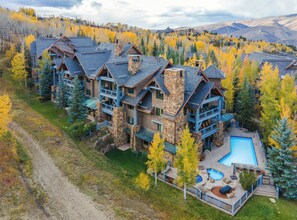 A large resort with multiple buildings, a swimming pool, and a scenic mountain backdrop. - Charlie's Slopeside: Bear Paw, Ski-In/Out, Sleeps 8, Bachelor Gulch + Ritz Pool & Hot Tub Access (Beaver Creek)