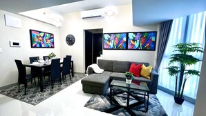 Ein modernes Wohnzimmer mit Essbereich, ausgestattet mit einer Couch, einem Couchtisch und einem Esstisch für vier Personen.