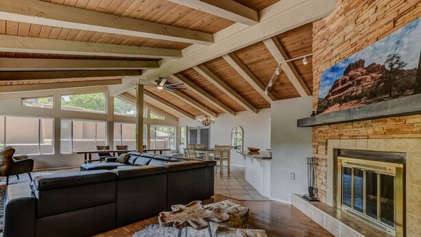 A spacious living area with a large sectional sofa, a fireplace, and a dining area with natural light.