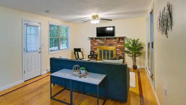 Una sala de estar con sofá, mesa de centro, chimenea y televisor.