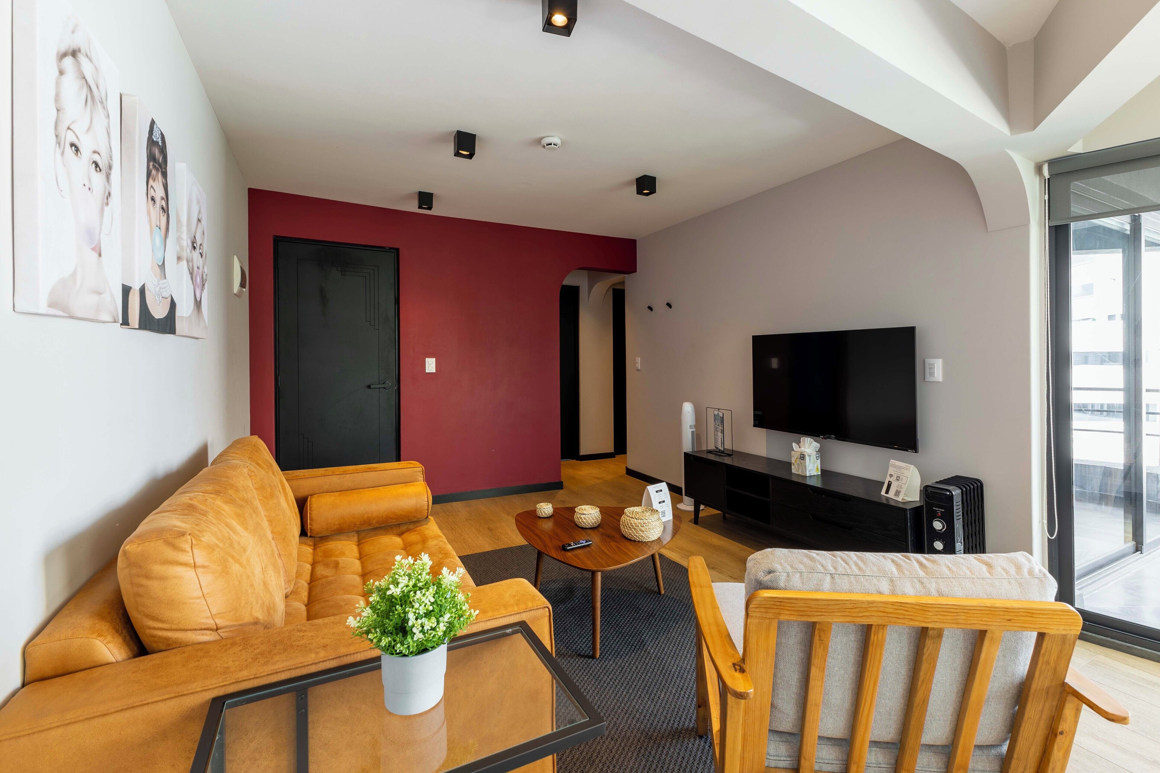 A modern living room with a sofa, armchair, coffee table, and a flat-screen TV.