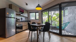 Eine moderne Küche mit Essbereich, großen Fenstern und Blick ins Freie.
