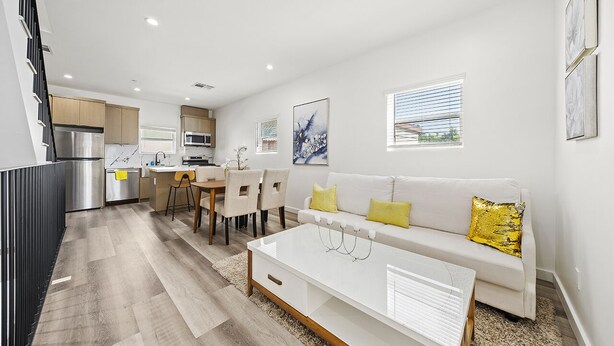 Un appartement moderne comprenant une cuisine, un coin repas et un salon.