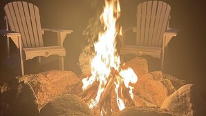 Due poltrone Adirondack rivolte verso un fuoco da campo.