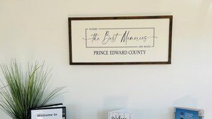 Un cartello di benvenuto per la contea di Prince Edward, una citazione incorniciata sui ricordi e un espositore per il libro degli ospiti.