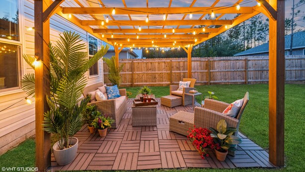 A covered patio with wicker furniture, string lights, and potted plants. - Historic Downtown - close to beaches - firepit - playground - pet friendly (St. Augustine)