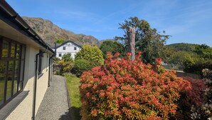 A house with a garden, a gravel path, and a mountain in the background. - Low How Cottage, Coniston, spacious single level, 4 bedroom cottage sleeping 10 (Coniston)