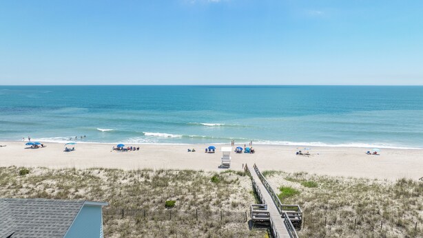 A beach with a wooden boardwalk leading to the shore, clear skies, and calm sea. - ‘B’ by the Sea: comfort and style, essentials included! (Carolina Beach)