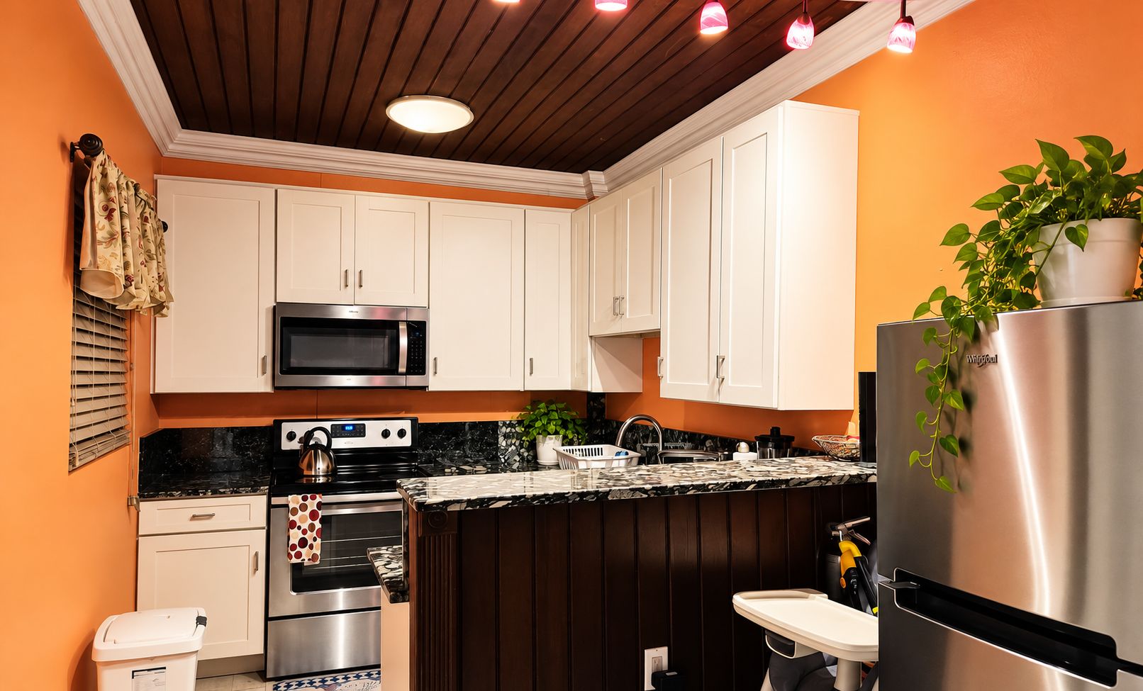 A modern kitchen with white cabinets, a stainless steel refrigerator, and a microwave.