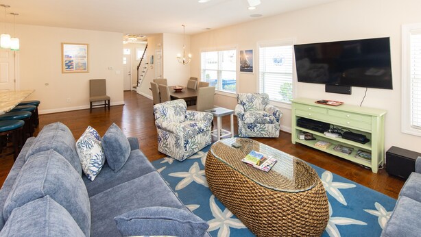 A living room with a sofa, armchairs, a coffee table, and a TV. - Beach Music - North End VB (Virginia Beach)