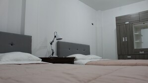 A bedroom with a bed, bedside table, lamp, and wardrobe. - Hospedaje Las Parraz (Subtanjalla)