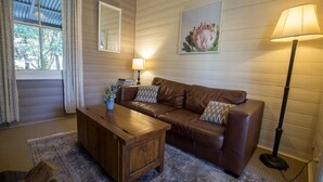 Un salon chaleureux avec un canapé en cuir marron, une table basse en bois et un lampadaire.