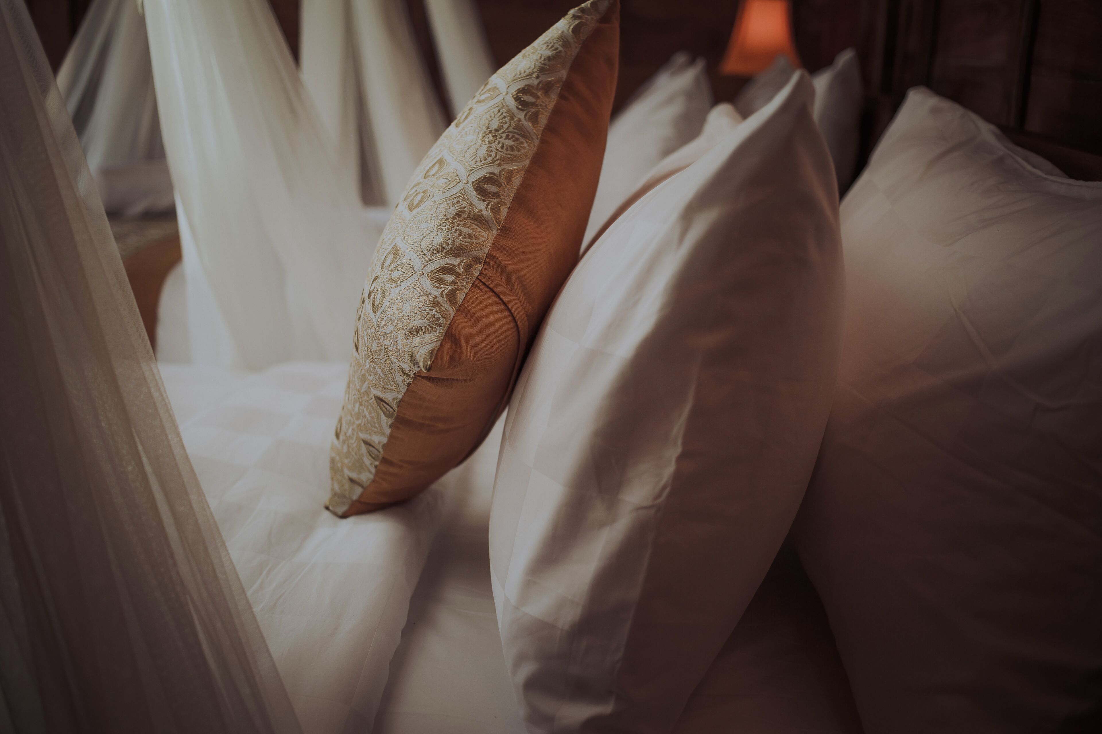 Cama com roupa de cama branca e um dossel.