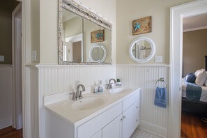 A bathroom with a double sink vanity, two mirrors, and decorative wall art. - Beautiful Beach House sleeps 12 (Biloxi)