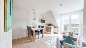 Un espacio habitable moderno y abierto, con comedor, cocina y balcón.