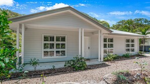 A single-story house with a gabled roof and a covered porch. - 11 Esprit Drive - Rainbow Shores. Gorgeous beach house. Walk to beach (Rainbow Beach)