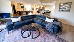 A modern living room with a sectional sofa, a coffee table, and a patterned rug.
