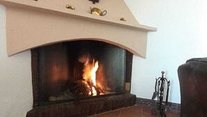 Una chimenea con suelo de baldosas y un faldón decorativo.