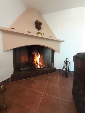 Ein Kamin mit gefliestem Boden und einem dekorativen Kaminvorsatz.