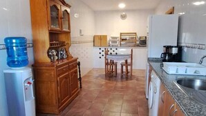 Una cocina con comedor, dispensador de agua y lavadora.