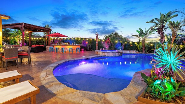An outdoor pool area with a pergola, seating, and a bar. - The Tulum House (San Diego)
