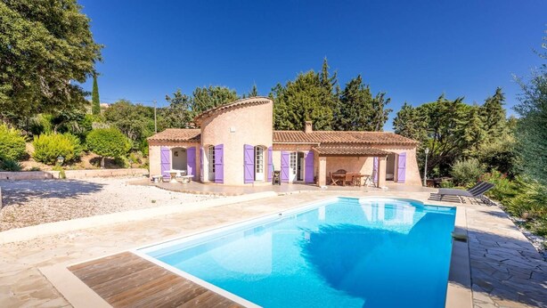 Une villa avec piscine, mobilier d’extérieur et jardin.