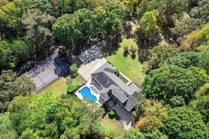 An aerial view of a house with a swimming pool, surrounded by dense greenery. - Grand Retreat: Luxury Vacation for Large Groups (Fayetteville)