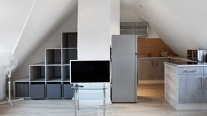 A modern kitchen with a built-in refrigerator, a glass table, and a fan. - Studio Apartment 'Vogelsberger Bett Die 2' with Wi-Fi (Alsfeld)