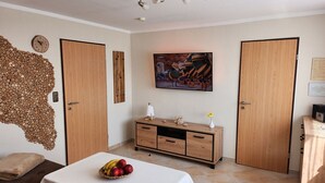 Una habitación con cama, un armario de madera, un reloj de pared y un cuadro.