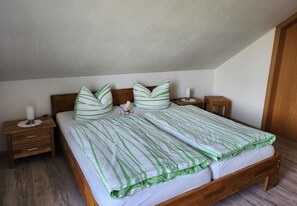 Une chambre à coucher avec un lit en bois, deux tables de chevet, une commode et une lampe de chevet.