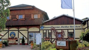 Een gebouw met een bord voor 'SaunaTherme, Heiber Brocken' en een logo voor 'Kristall'.